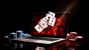 laptop with playing cards and casino chips
